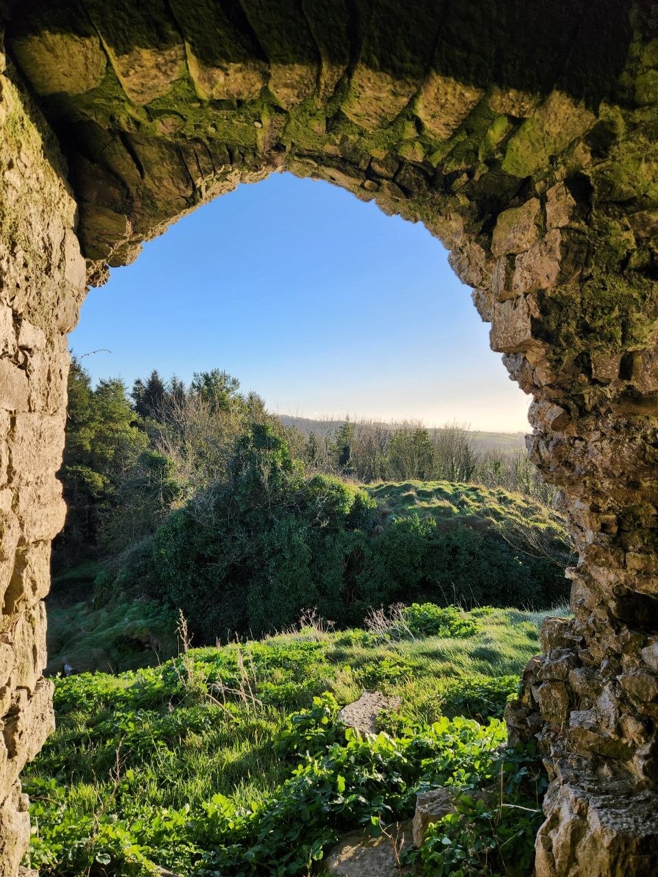 A view through a stone arch into the Irish landscape